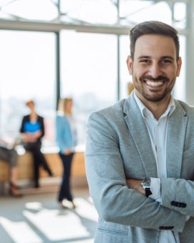 Portrait of a smiling handsome businessman with crossed arms.